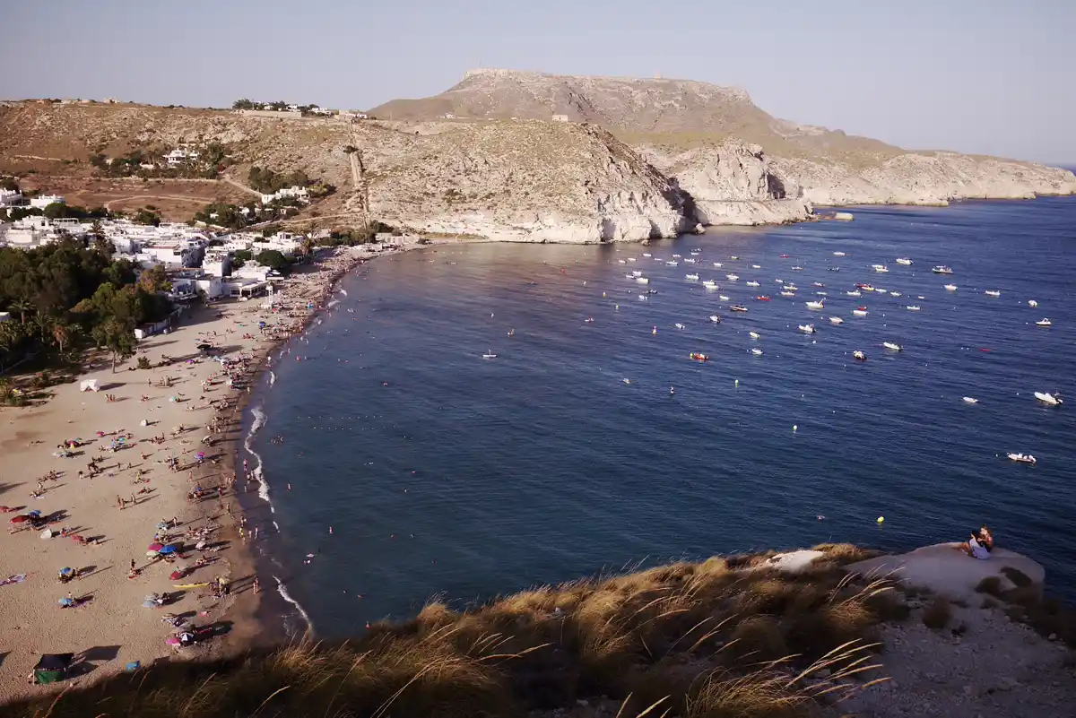 Playa de Agua Amarga con barcas fondeadas en la bahía