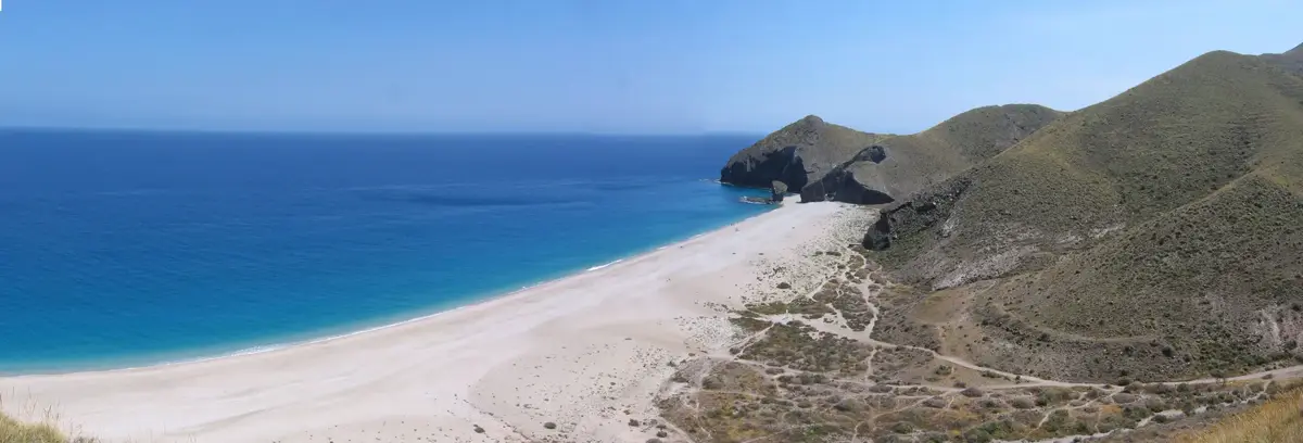 Panorámica de la Playa de los Muertos con el mar azul, la playa blanca y los senderos entre la vegetación